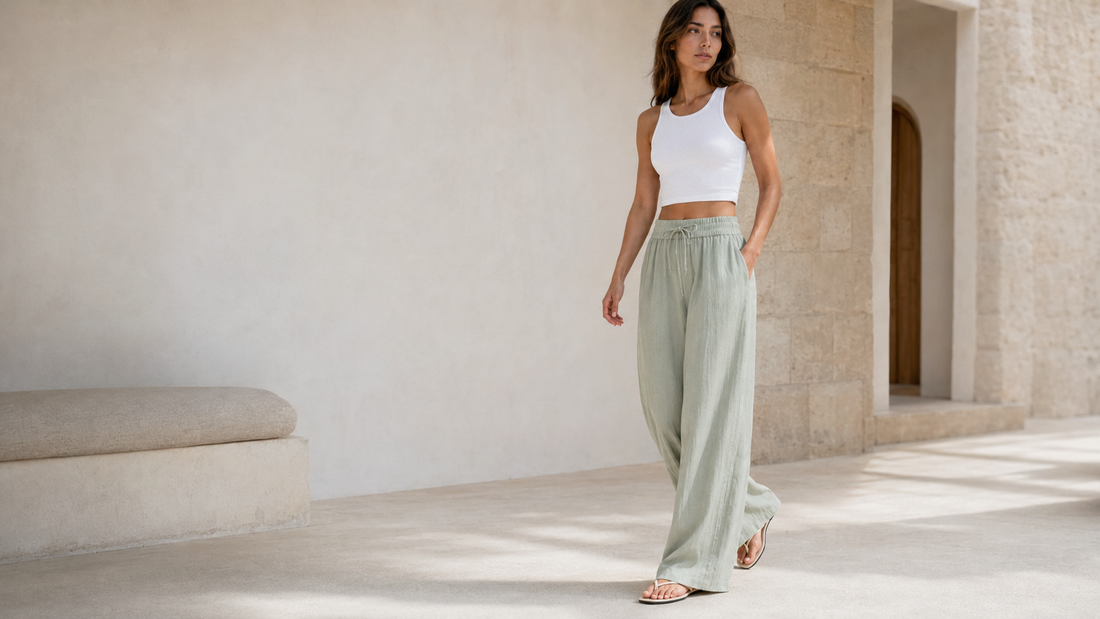 Woman wearing sage wide-leg Mirea Pants in a minimal Mediterranean setting